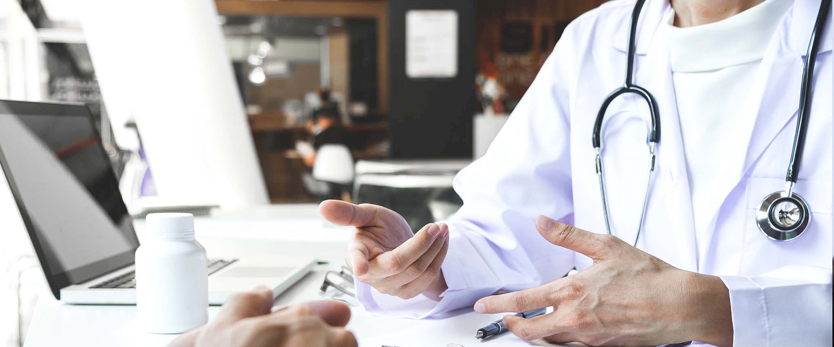 Closeup of a doctor sitting across the desk from a patient