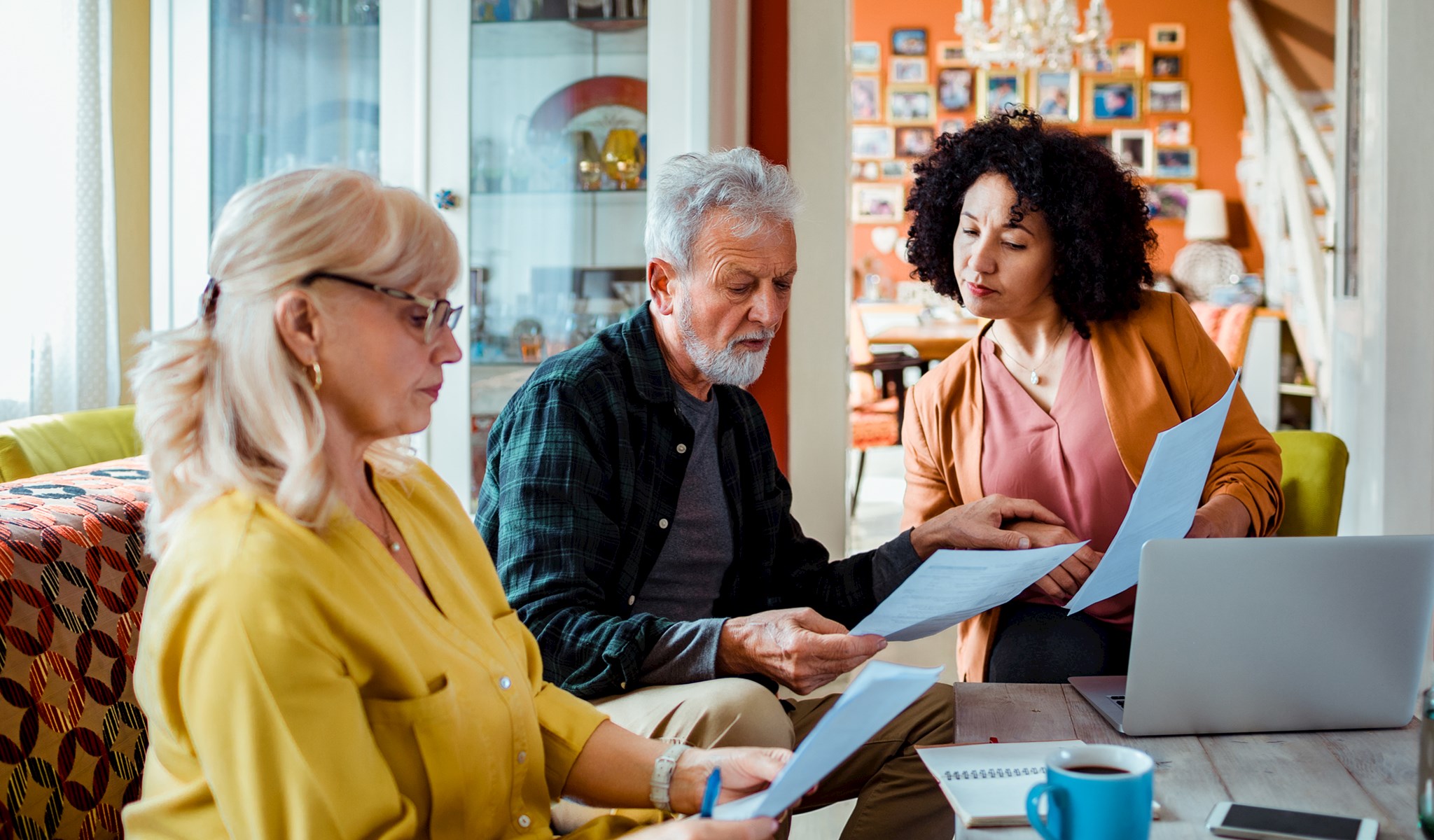 Three people sitting around a table looking at papers