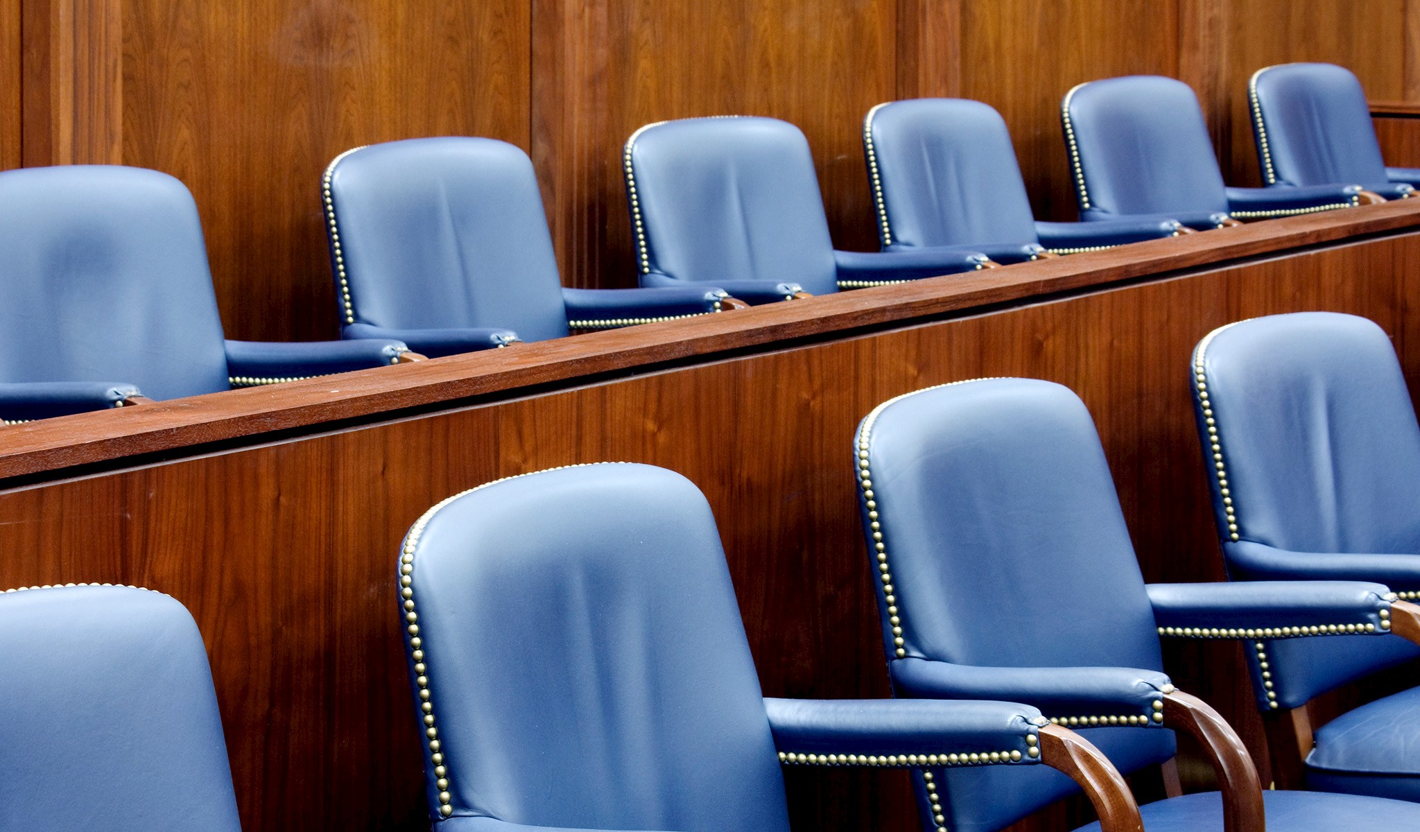 An image of empty chairs in a courtroom setting